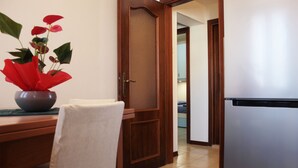 A kitchen with a refrigerator, a wooden door, and a plant on the counter. - Moira's House (Venezia)