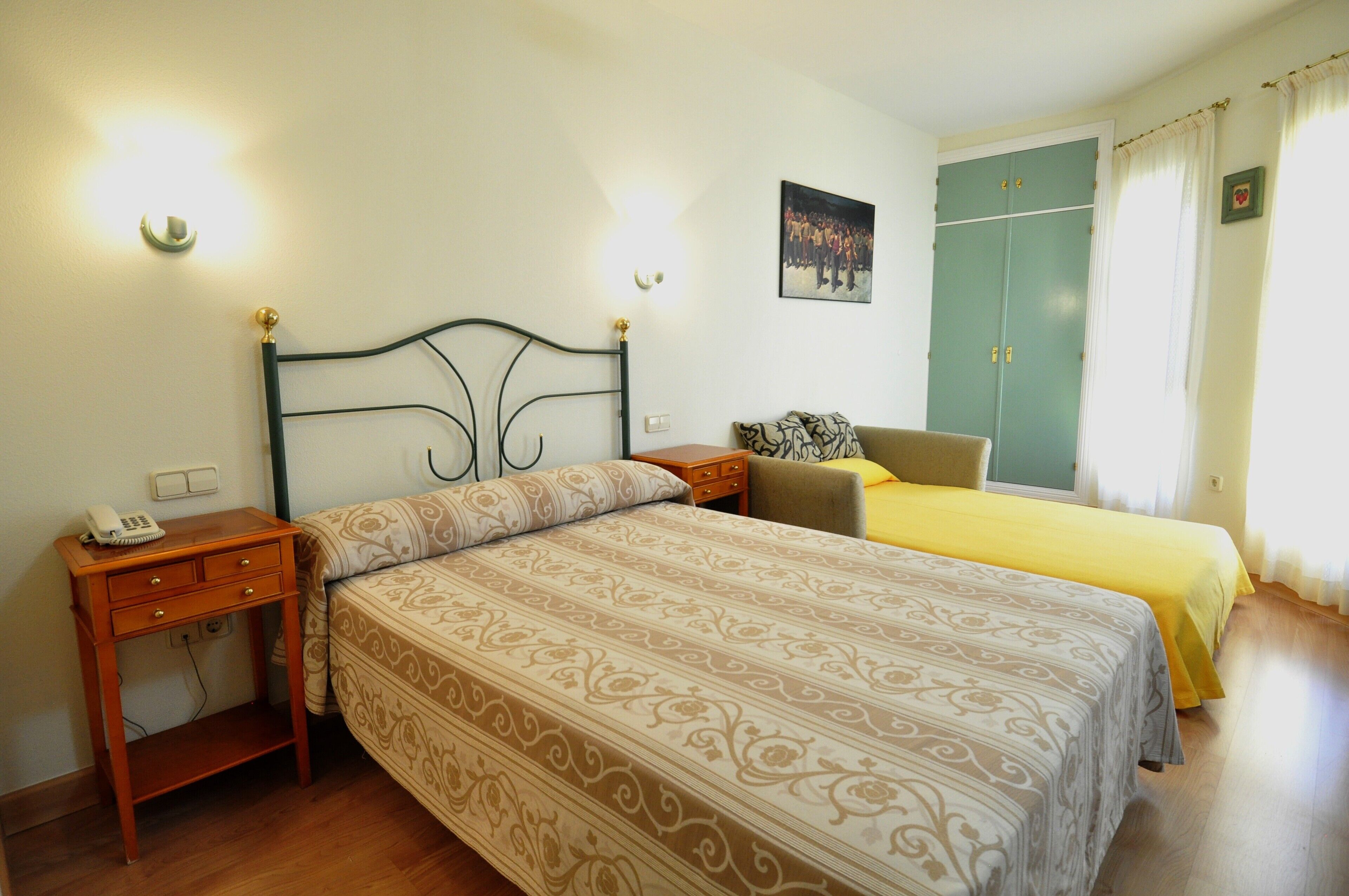Une chambre à coucher avec un lit, une table de chevet, une lampe et une armoire.