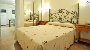 Une chambre à coucher avec un lit double, un miroir, des tables de chevet et une armoire.