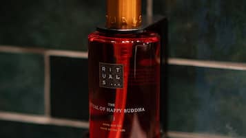A bottle of Rituals hand wash soap on a reflective surface.