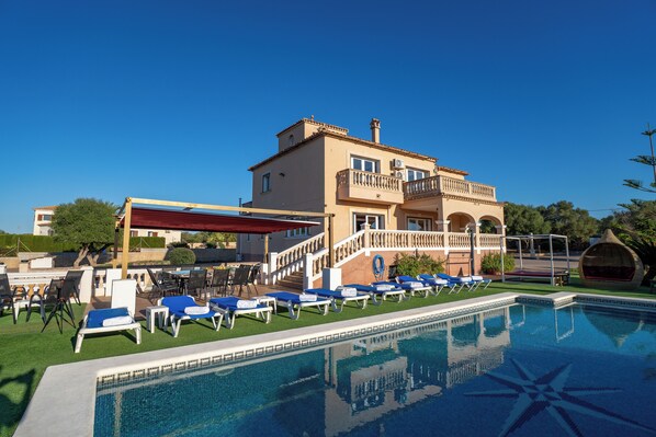 A poolside area with lounge chairs and a covered seating area.
