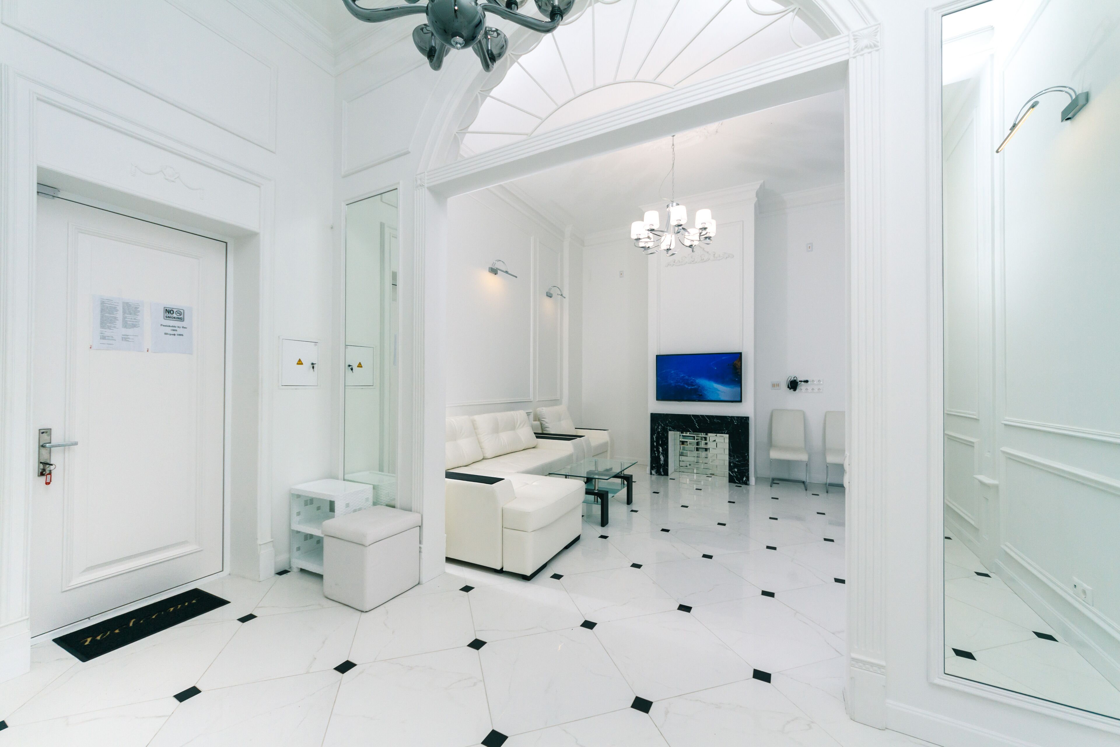 A modern living room with a white sofa, a glass coffee table, and a flat-screen TV.
