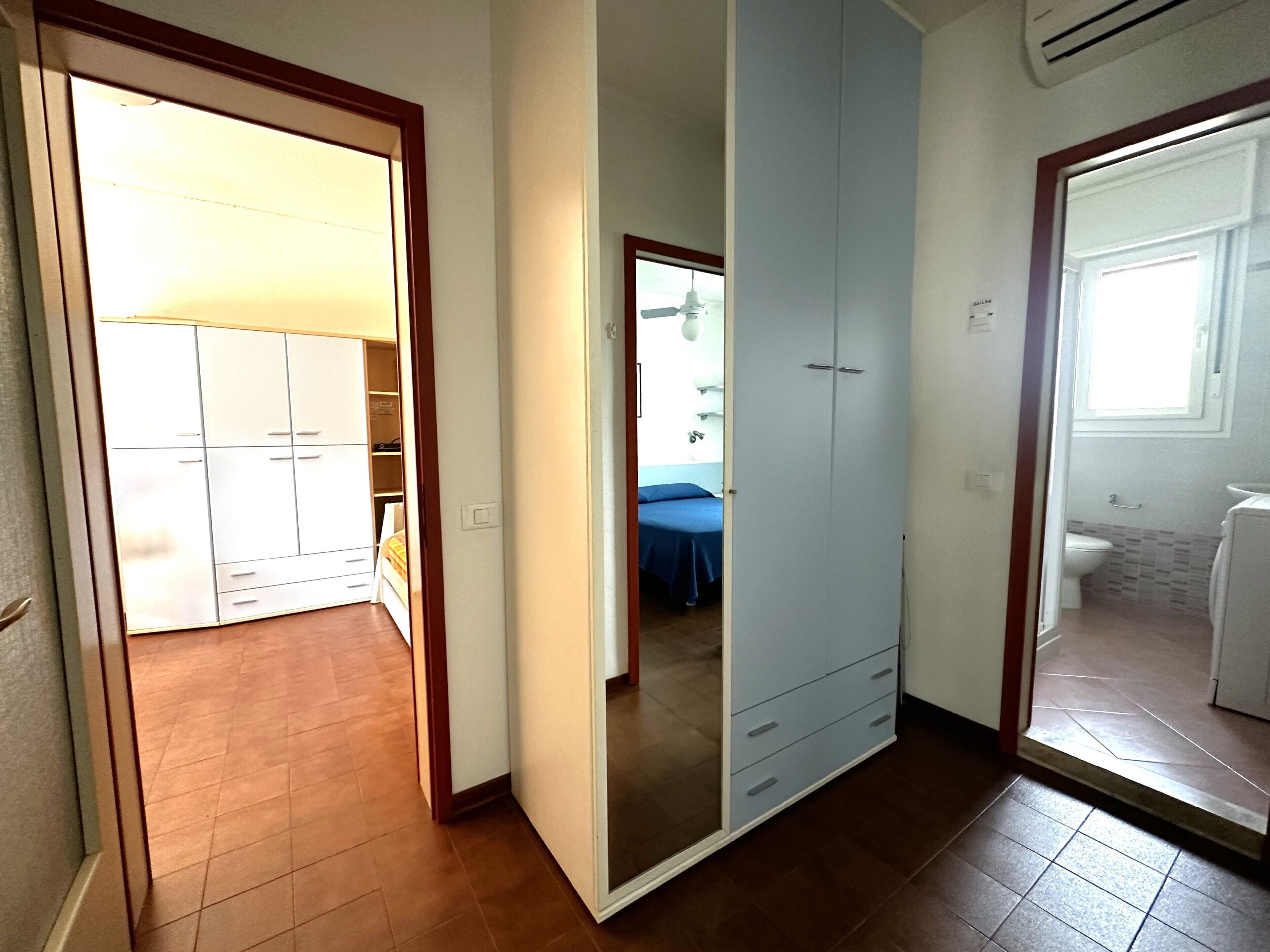Una habitación con armario, cama y baño.