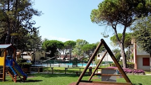 A playground with a swing set, slide, and a small pool.