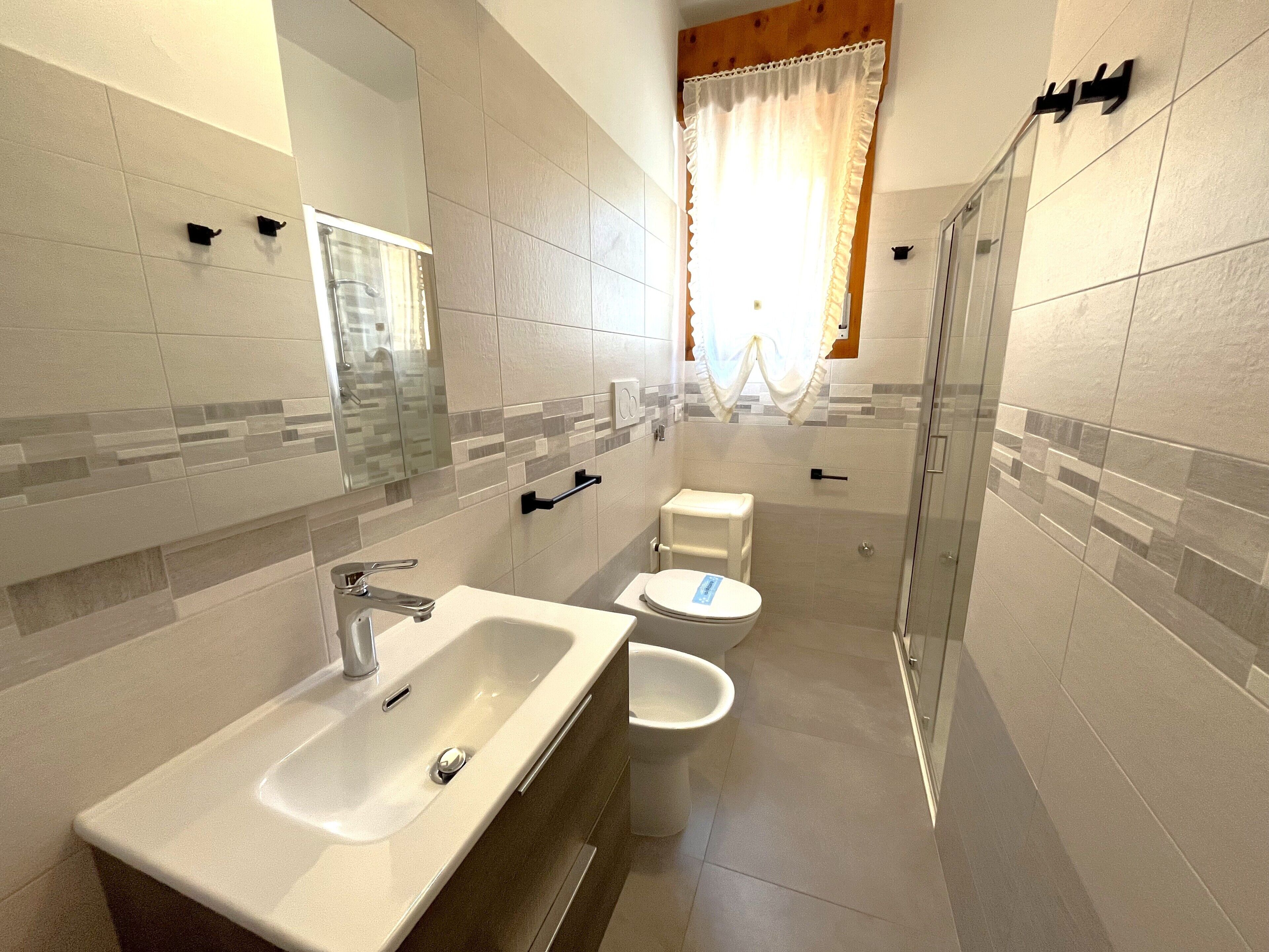 Une salle de bain moderne avec un lavabo, des toilettes et une douche.
