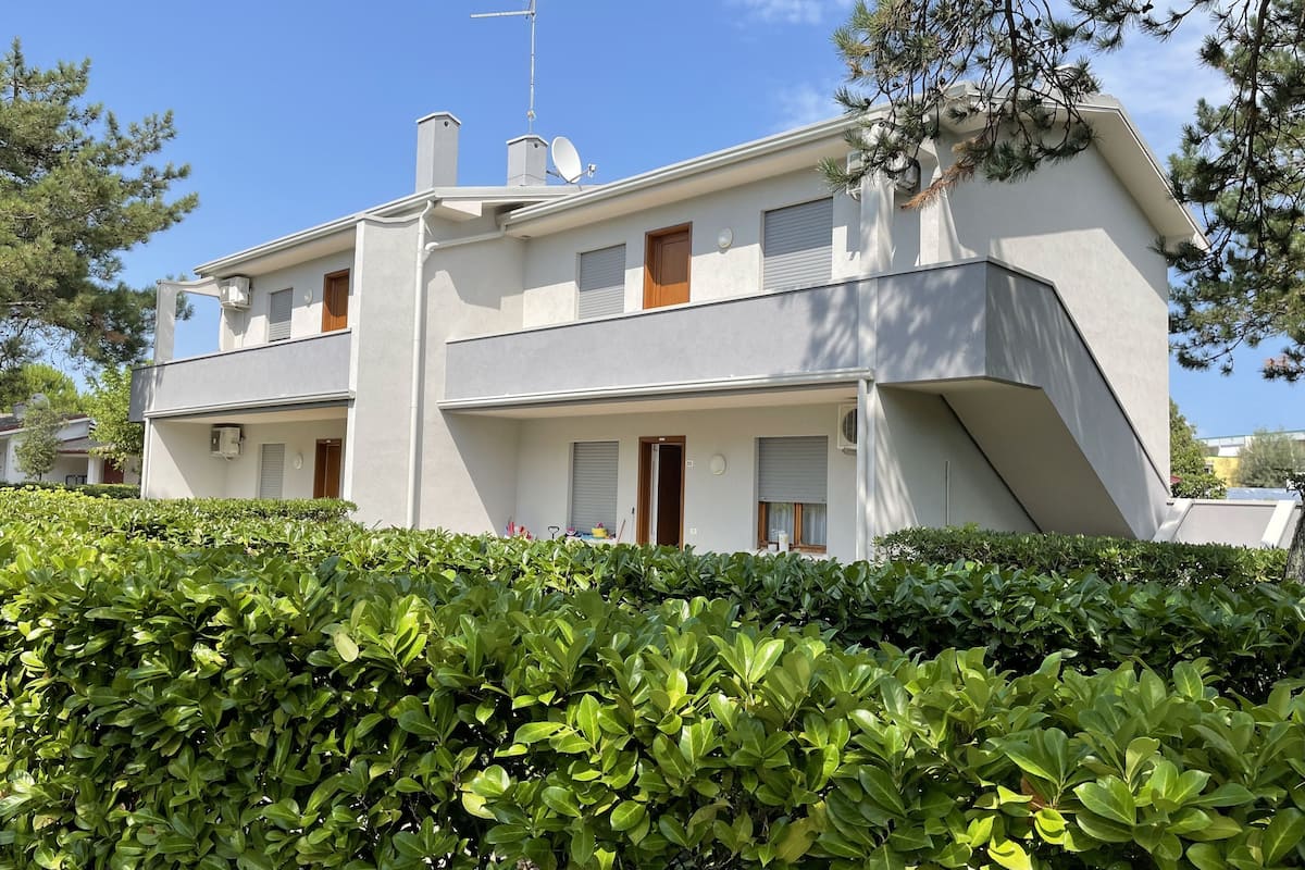 Un bâtiment à deux étages, de style architectural moderne, doté d’un toit plat, d’une antenne parabolique et d’une cheminée.