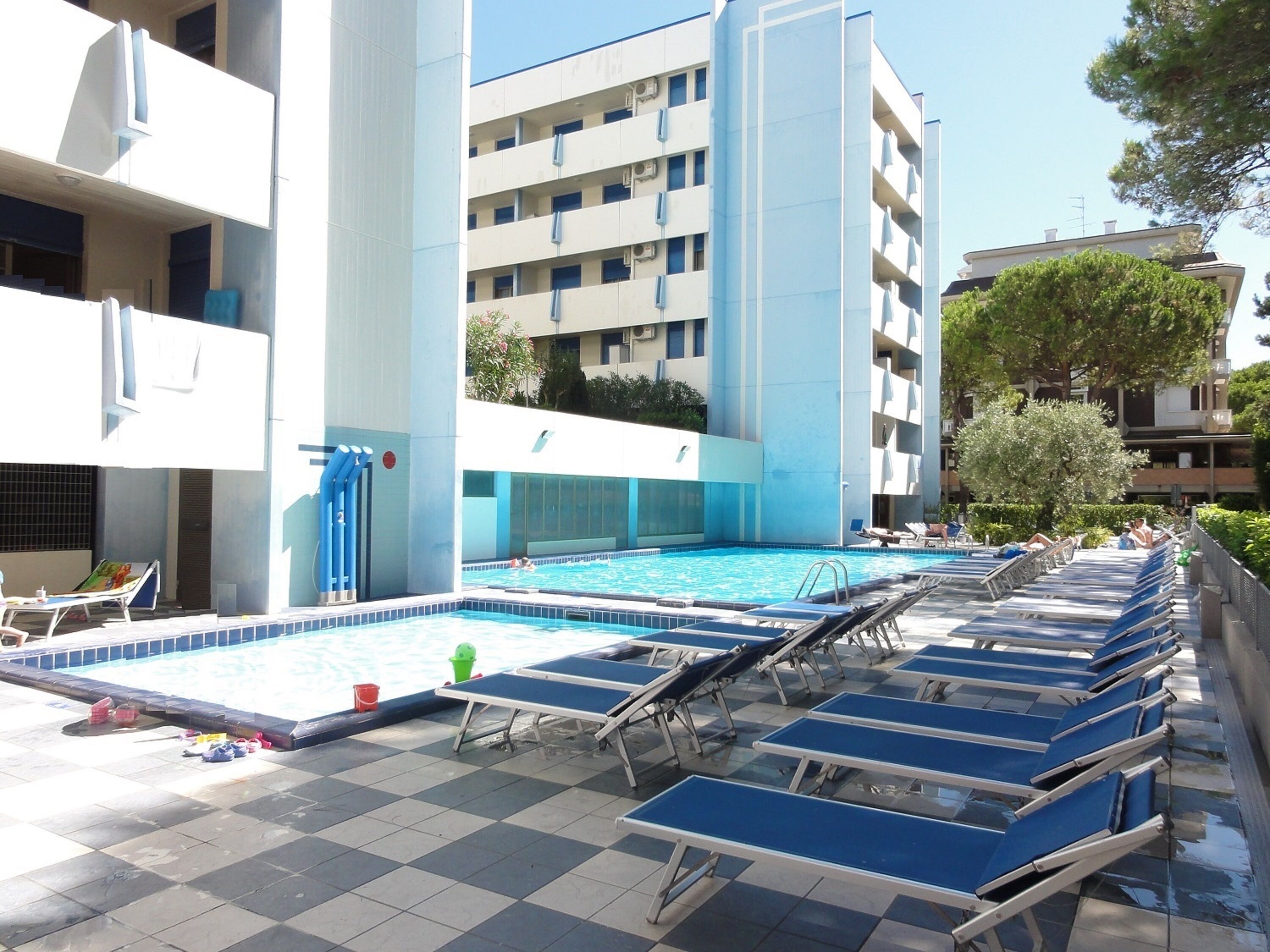 Una piscina al aire libre de temporada, sillones reclinables de piscina