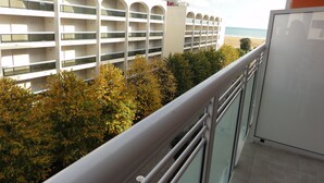 Et hotel med moderne arkitektur, med en flereetagers bygning, altaner og udsigt til stranden.