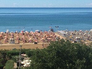 A beach with numerous umbrellas and sun loungers, indicating a beach resort setting.