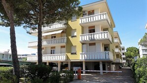A multi-story residential building with balconies, a parking area, and a gated entrance. - Condominio Diana Est (San Michele al Tagliamento)