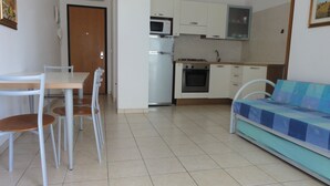 Ein kompakter Wohnbereich mit Essbereich, Küchenzeile und Sofa.