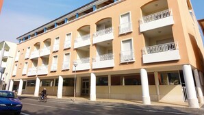 Ein mehrstöckiges Hotel mit Balkonen, einer Fahrradstraße und blauem Himmel.