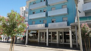 A multi-story building with balconies, a storefront with signage, and a street lamp. - Condominio Molent (San Michele al Tagliamento)