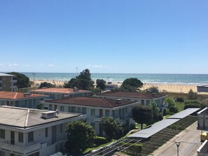 A residential area with buildings, a beach, and a clear sky.