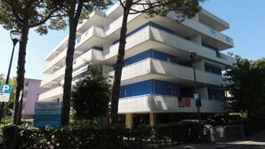 Un edificio residencial de varios pisos con balcones, un cartel de estacionamiento y un letrero que indica 'Condominio SABRINA'.
