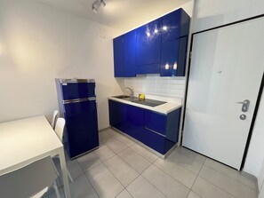 Full-size fridge, stovetop, electric kettle, cookware/dishes/utensils