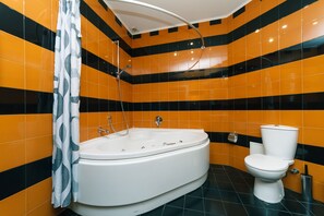 Une salle de bain avec une baignoire blanche, des toilettes et une douche.