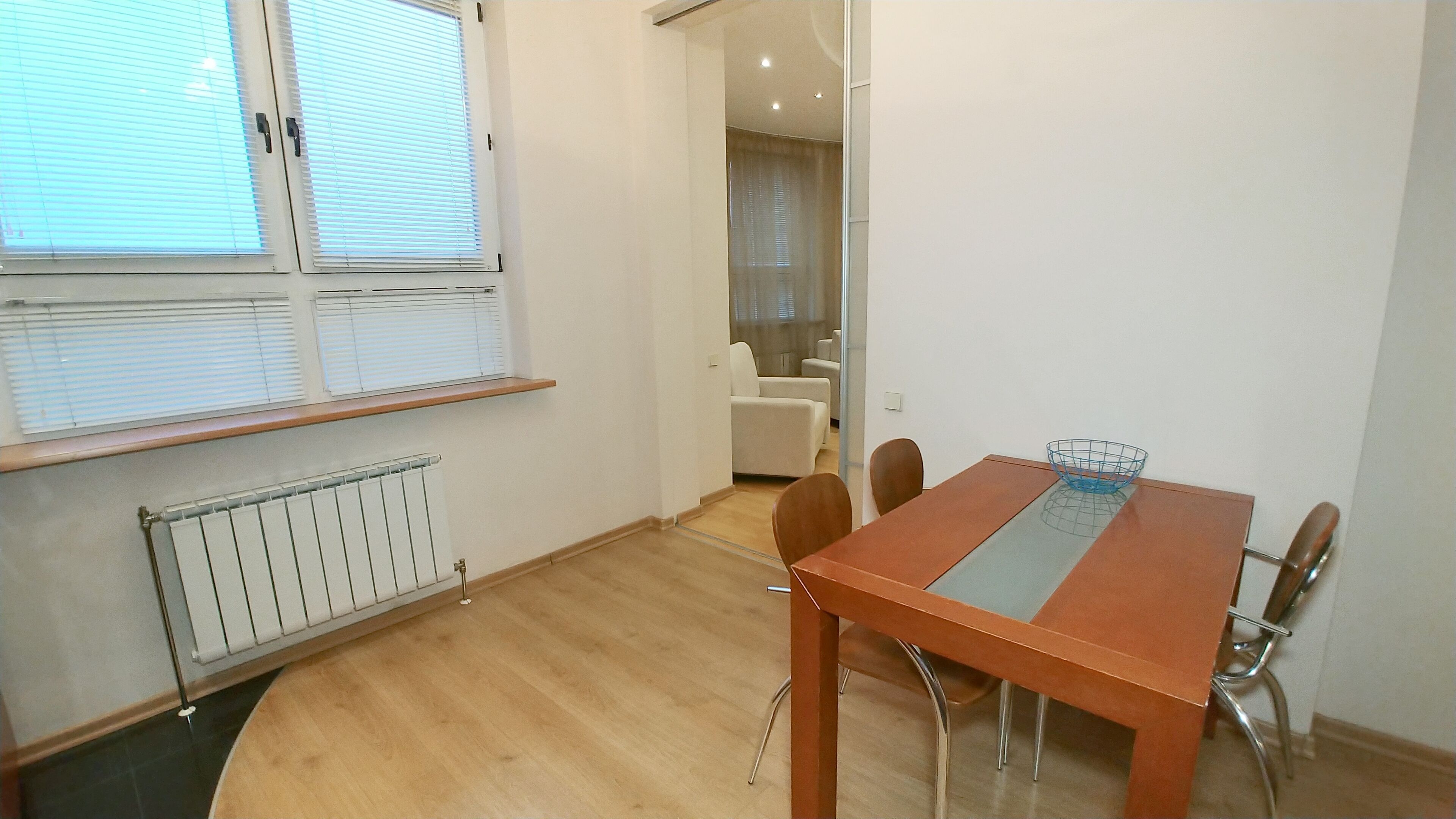 Een eethoek met een houten tafel, stoelen en een radiator.