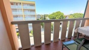 A balcony with a tiled floor, a table, and a chair. - Condominio Storione (San Michele al Tagliamento)