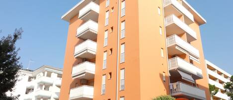 A multi-story building with balconies and a flat roof.