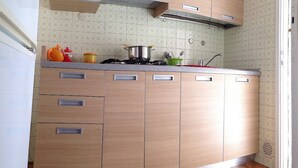 A kitchen with wooden cabinets, a gas stove, and a tiled backsplash.