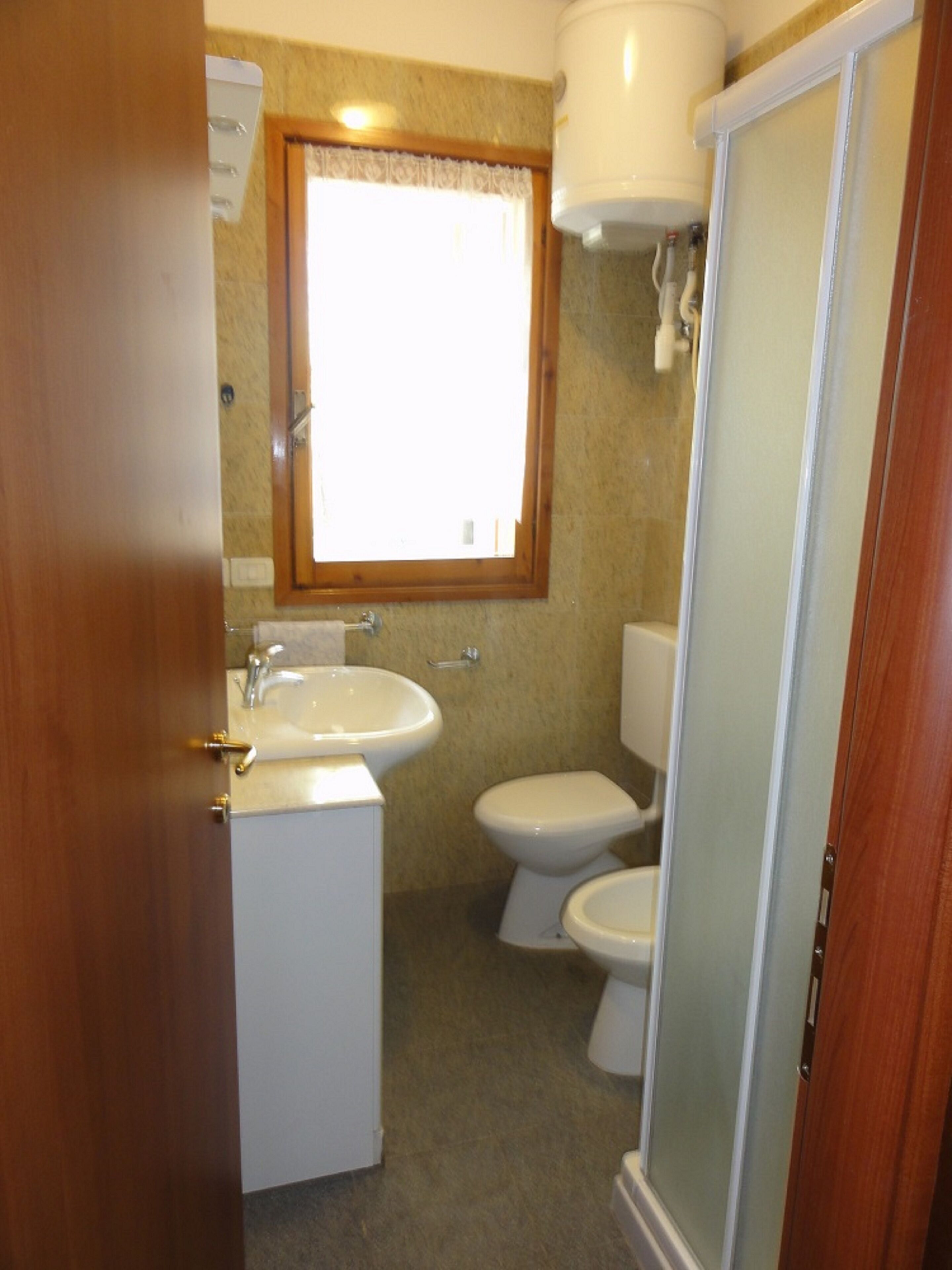 A bathroom with a sink, toilet, and shower.