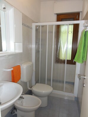 A bathroom with a toilet, bidet, and sink.