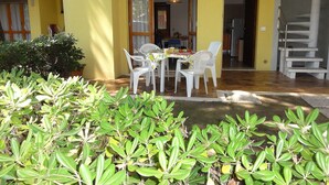 A patio with a table and chairs, a staircase, and a potted plant. - Villaggio White Star (San Michele al Tagliamento)