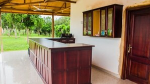 A kitchen with a wooden island, a cabinet with glass doors, and a door.