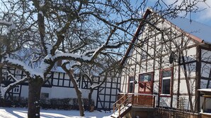 A traditional half-timbered building with a wooden staircase leading to a balcony.