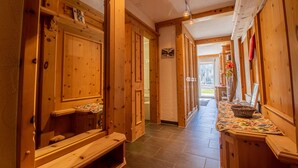 A wooden hallway with benches, a basket, and a floral tablecloth. - Villa Franca UO (Arosa)