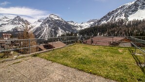A mountainous landscape with snow-covered peaks, a fenced area with buildings, and a clear sky. - Villa Franca UO (Arosa)