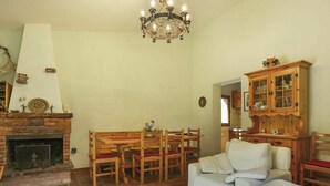 Una sala de estar con chimenea, muebles de madera, una araña y un aparador.