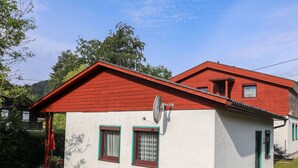 A two-story house with a red roof and white walls.