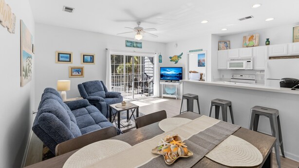 A modern living room with a sofa, TV, and dining area.