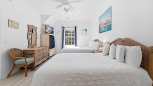 A bedroom with a large bed, a dresser, a chair, and a window with curtains.