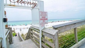 A gated entrance to Ciboney Condominiums with a wooden staircase leading to the beach. - Ciboney Beach Resort Panhandle Getaways (Miramar Beach)
