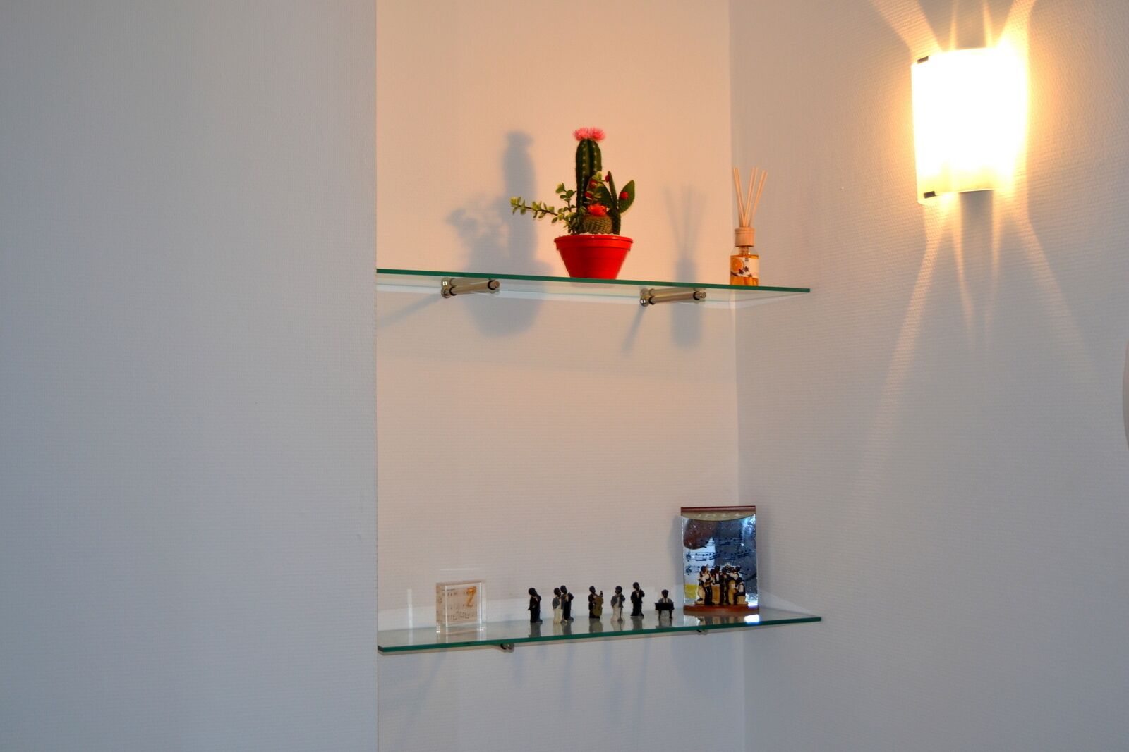Un estante con un cactus y una pequeña colección de figuritas.