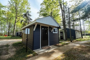 A small, single-story cabin with a gabled roof and a front porch. - Hidden Haven Cottages (Lake City)