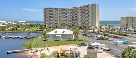 A coastal hotel with multiple floors, a parking lot, and a marina with boats.