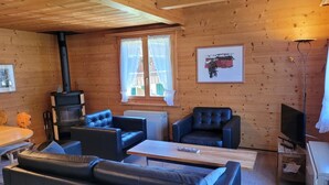 A cozy cabin interior with a fireplace, leather sofas, a small table, and a television. - Lovely apartment for 4 people with balcony (Lenk)