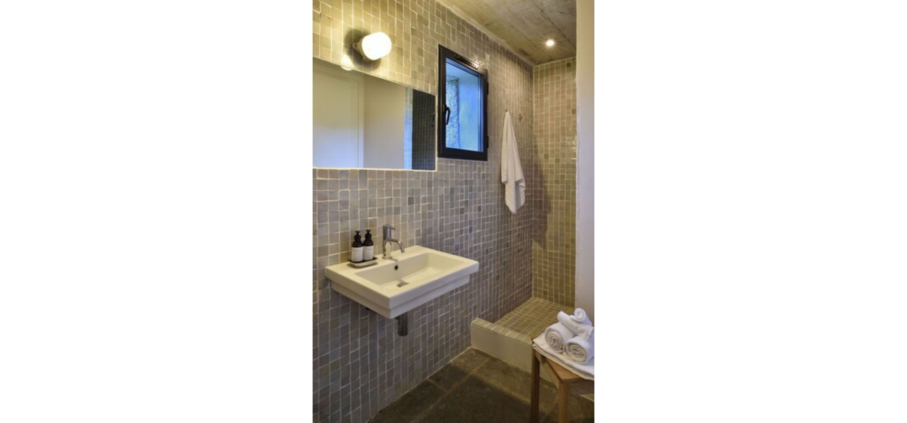 Ein Badezimmer mit Waschbecken, Spiegel und Handtuchhalter.