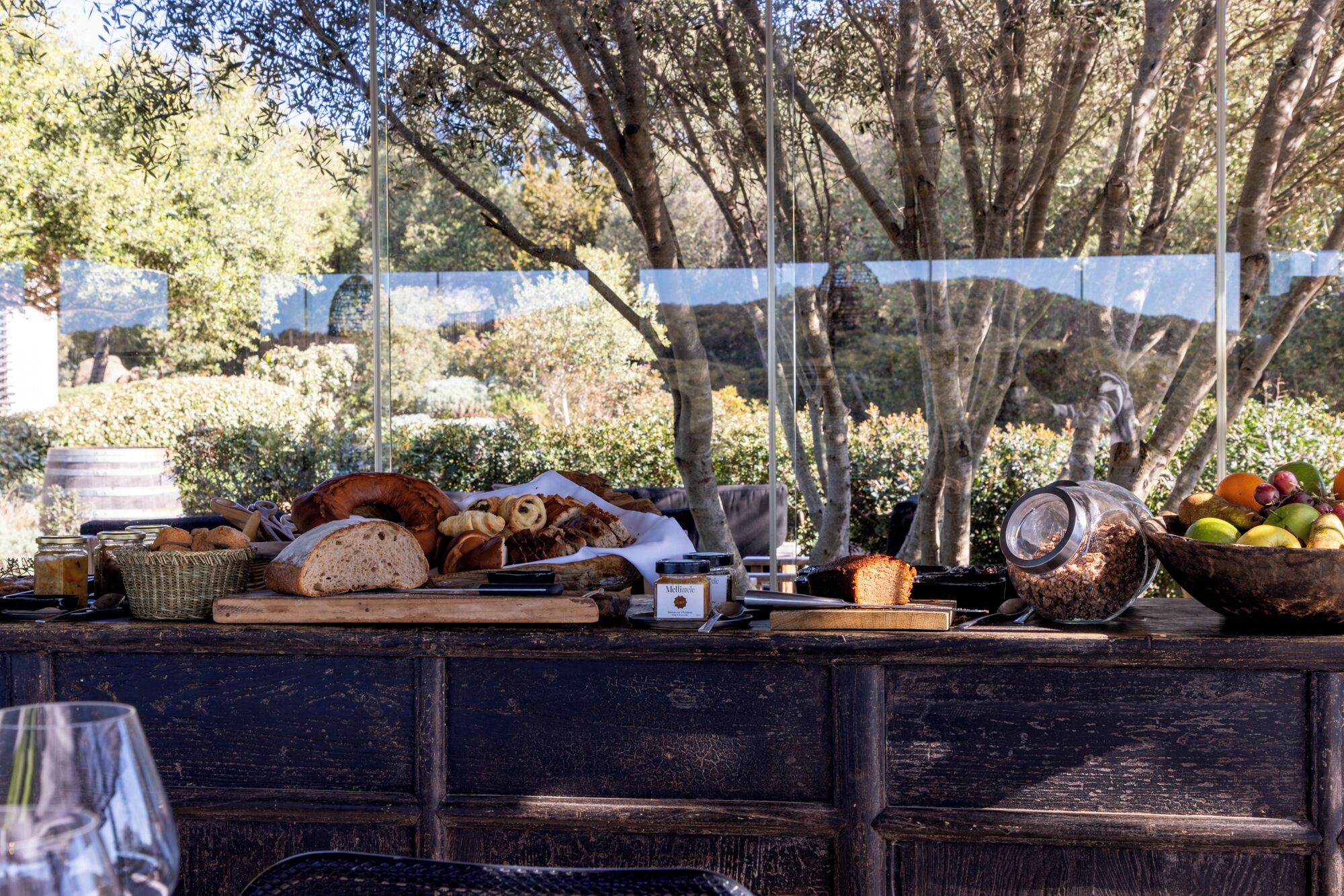 An outdoor dining area with a variety of breads, pastries, and fruits.