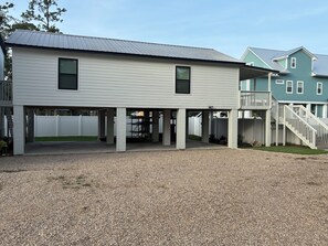 A two-story building with a covered patio area and a staircase leading to a deck. - Waterfront House with floating Boathouse, can sleep 7. Boat ramp .6 miles (Steinhatchee)