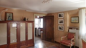 A room with a wooden cabinet, a red upholstered chair, and a radiator. - Ca' San Lorenzo spectacular view (Venezia)