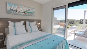 A bedroom with a large bed, a painting of sailboats, and a balcony with outdoor furniture. - Luxury Villa With Private Pool in Cesseras (Cesseras)