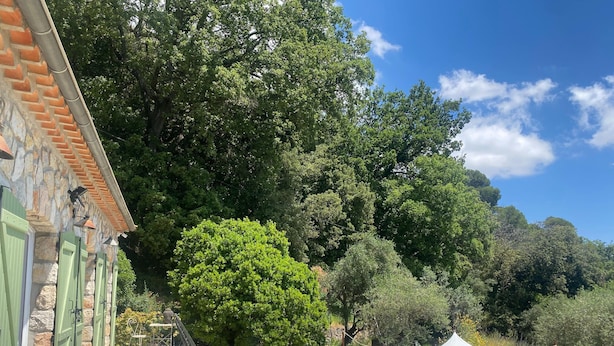 A terrace with outdoor seating, a stone building, and lush greenery. - Villa in Grasse With Private Pool (Grasse)