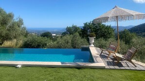 A pool with a view of the sea, surrounded by greenery and a pergola with a canopy. - Villa in Grasse With Private Pool (Grasse)