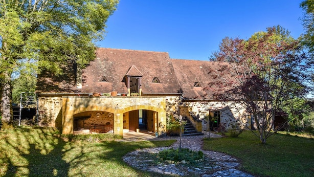 A stone building with a tiled roof, arched entrance, and a stone staircase leading to the entrance. - Pool Escape in Saint-laurent (Saint-Laurent-la-Vallee)