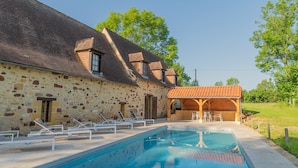 A stone building with a swimming pool, lounge chairs, and a covered outdoor seating area. - Pool Escape in Saint-laurent (Saint-Laurent-la-Vallee)
